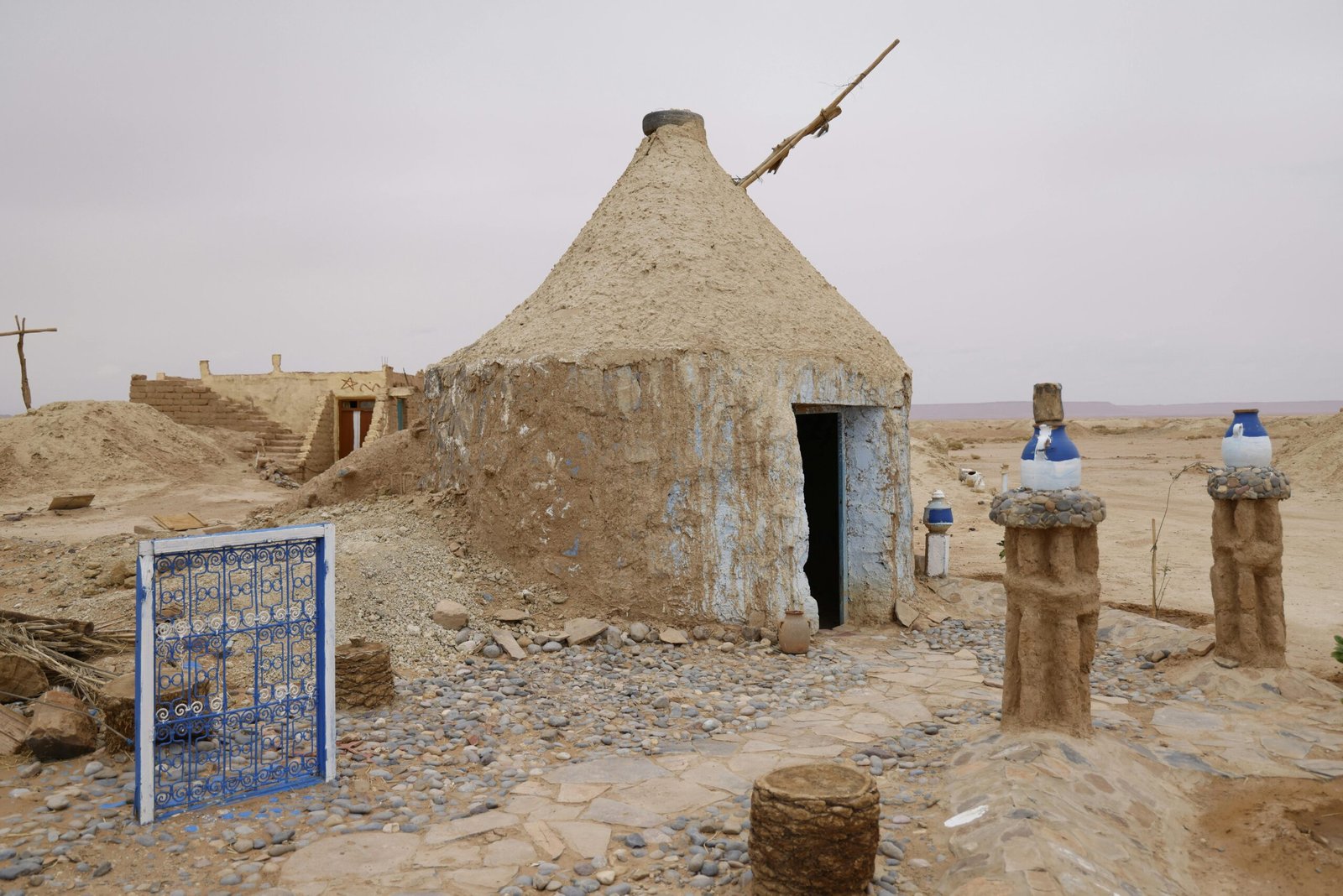 Adobe-style mud hut in a rural desert setting, reflecting traditional architecture.